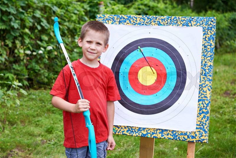 Little archer with bow, aim and arrow outdoors, stock photo