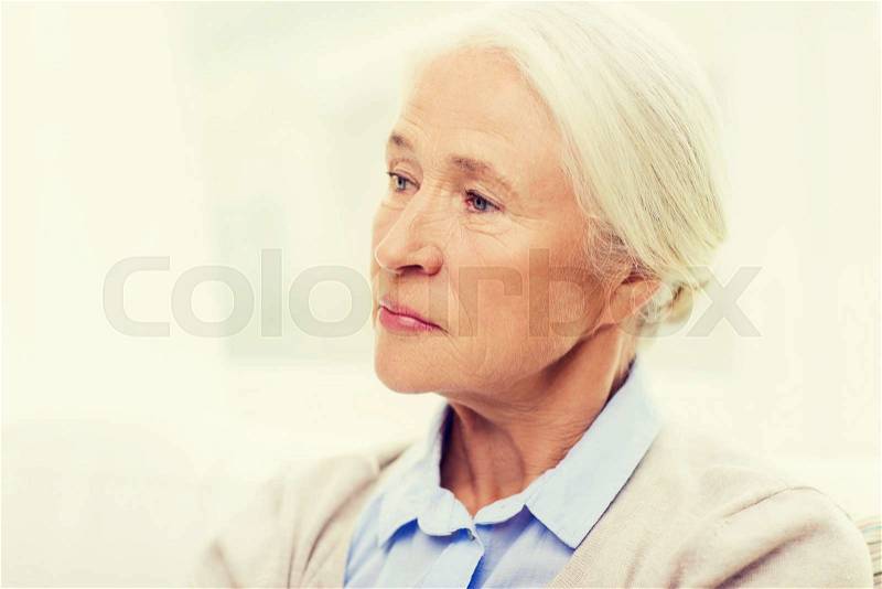 Age, emotion, sadness and people concept - senior woman face at home, stock photo