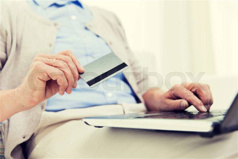 Technology, age and people concept - close up of senior woman with laptop compute and credit or bank card r at home, stock photo