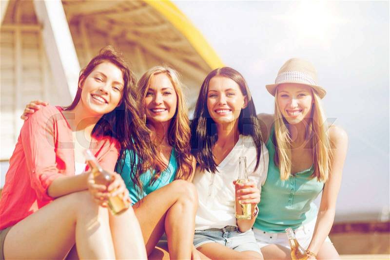 Summer holidays and vacation - girls with drinks on the beach, stock photo