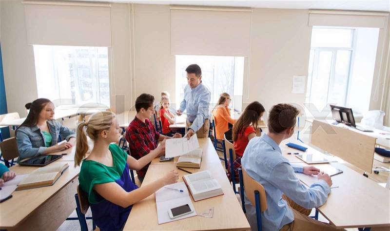 Education, school, learning and people concept - group of students and teacher with test results in classroom, stock photo
