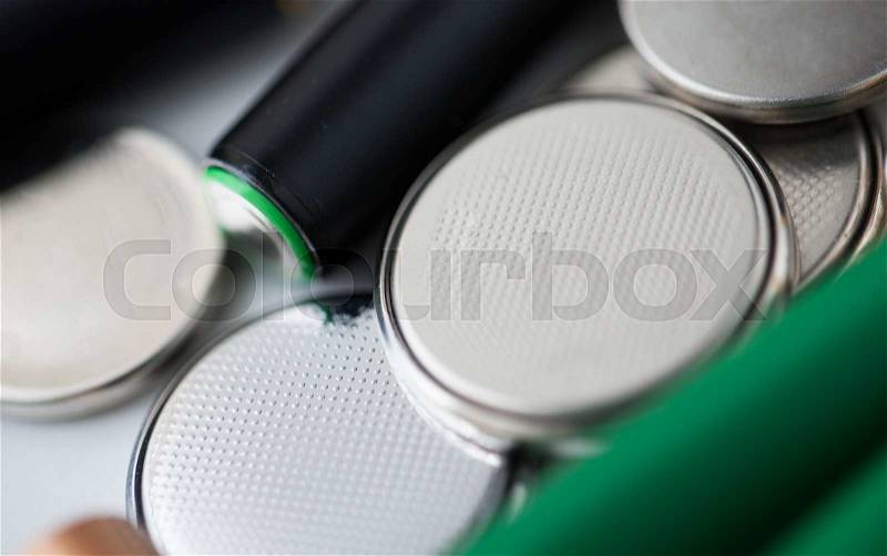 Recycling, energy, power, environment and ecology concept - close up of alkaline batteries heap, stock photo