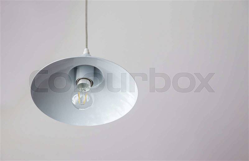 Warm lighting coming out from beautiful lamps on ceiling. Electric lamp in dark in a cafe, stock photo