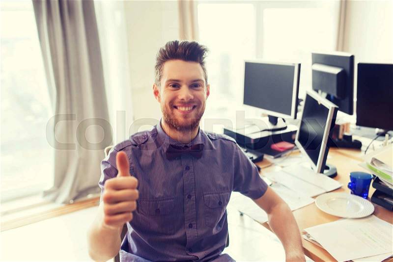 Business, startup, gesture and people concept - happy businessman or creative male office worker with computers showing thumbs up, stock photo
