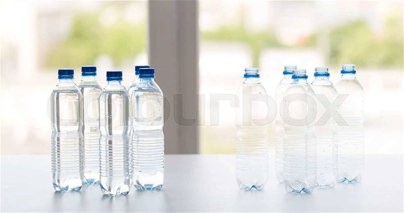 Recycling, healthy eating and food storage concept - close up of plastic bottles with pure drinking water on table, stock photo