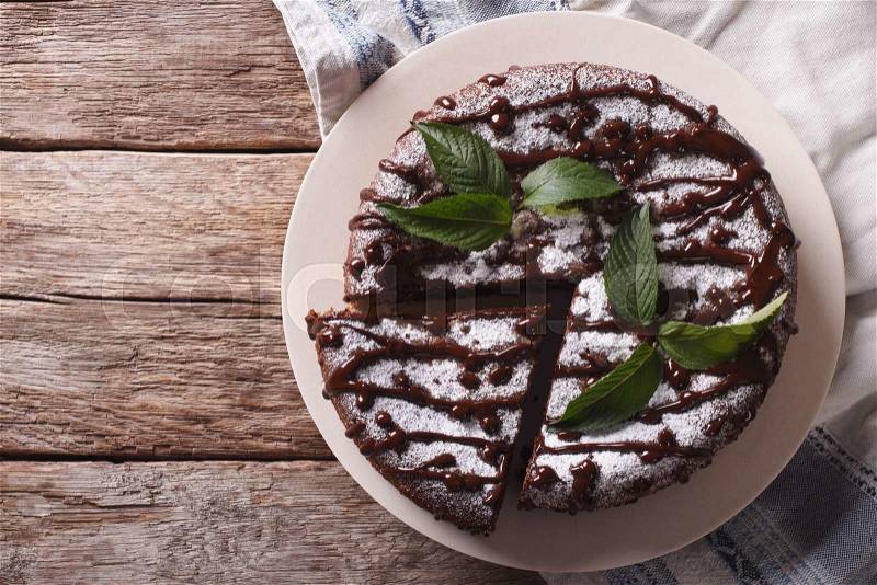 Tasty cake with poppy seeds and powdered sugar and mint close-up on the table. Horizontal view from above , stock photo