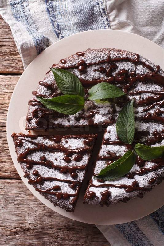 Freshly baked pie with poppy seeds and powdered sugar and mint close-up on the table. vertical view from above\, stock photo