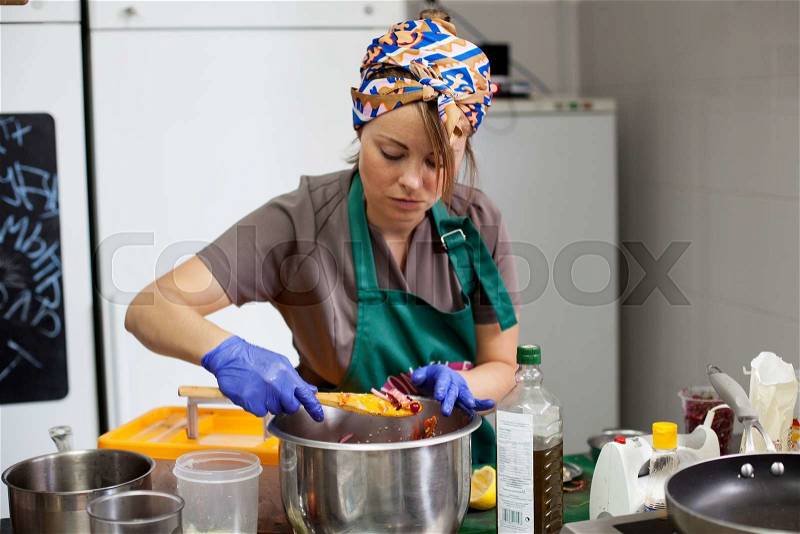 Woman cook preparing food in the pan at the kitchen of a fastfood restaurant, stock photo