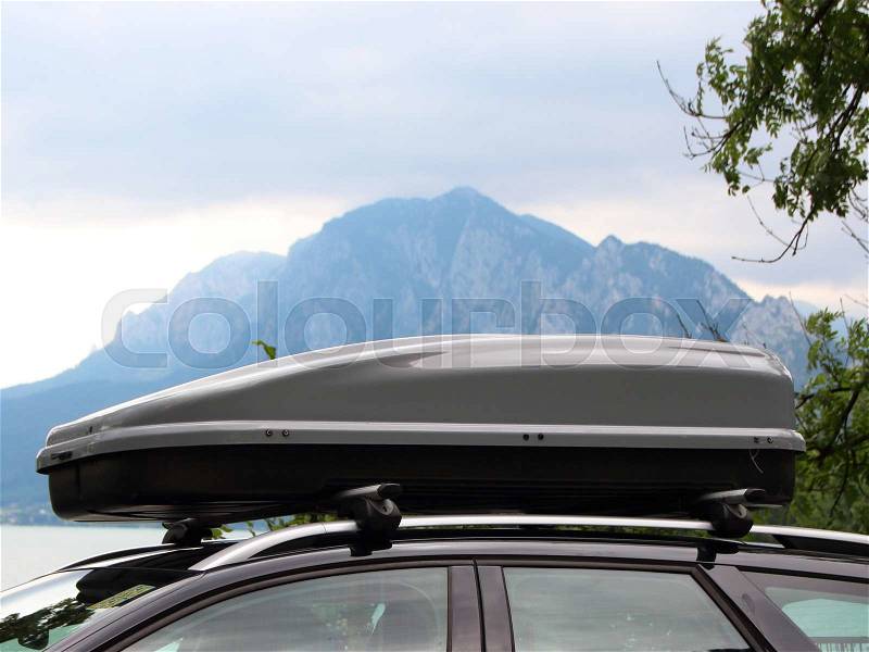 Car Rooftop Box with Cloudy Mountain and Lake in Background Horizontal, stock photo