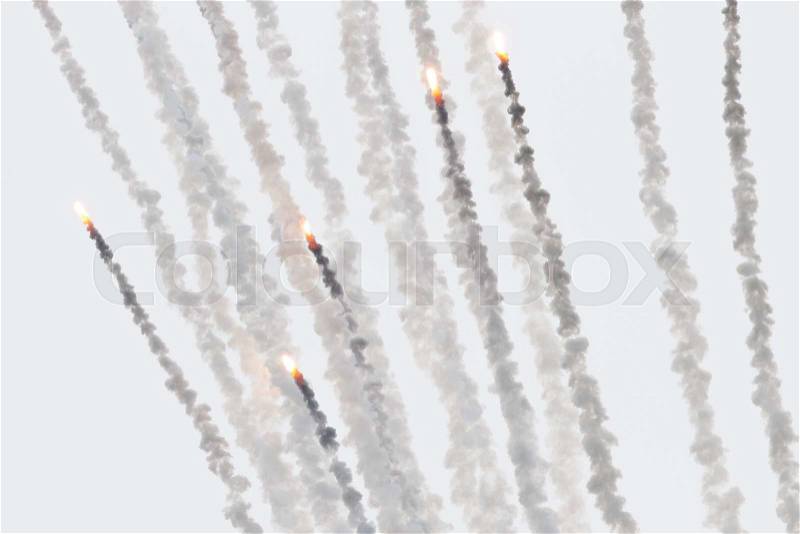 Flares with a trial of smoke, fired from a military jet, stock photo