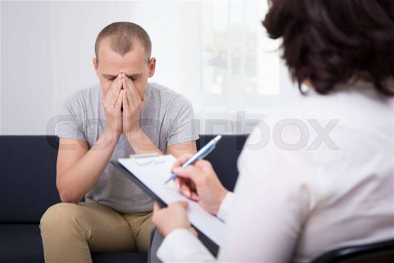 Boss dismissing an employee - young sad man in office, stock photo