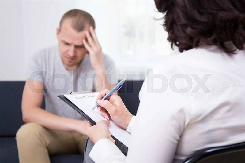 Young sad man patient and female doctor in office, stock photo