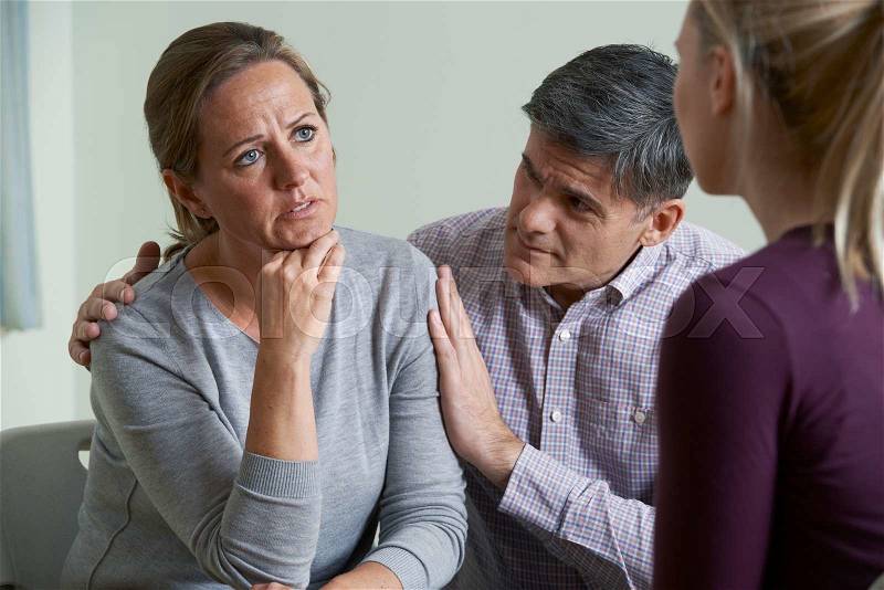 Mature Couple Talking With Counsellor As Man Comforts Woman, stock photo