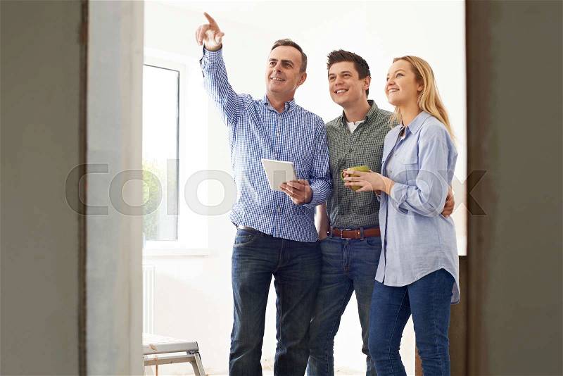 Couple Meeting With Architect Or Builder In Rennovated Property, stock photo