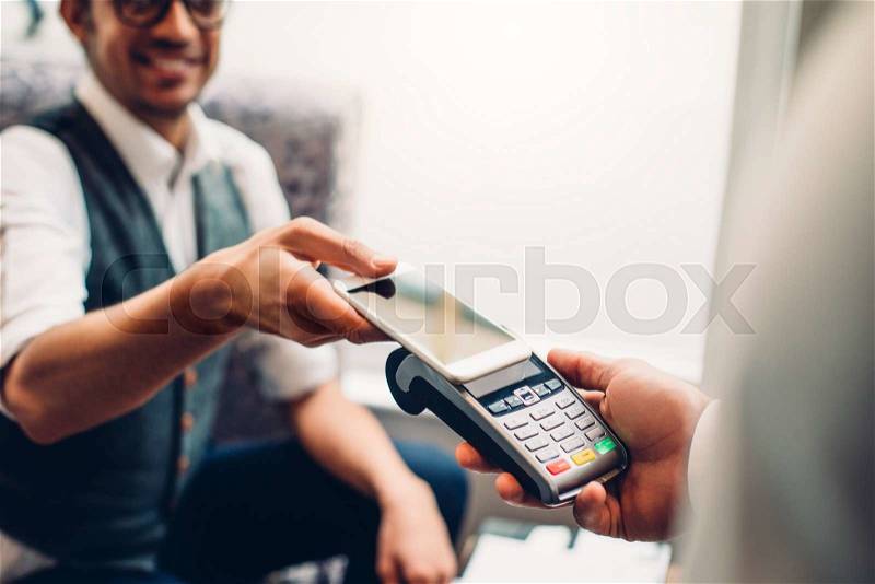 Business man making a contactless smartphone payment, stock photo