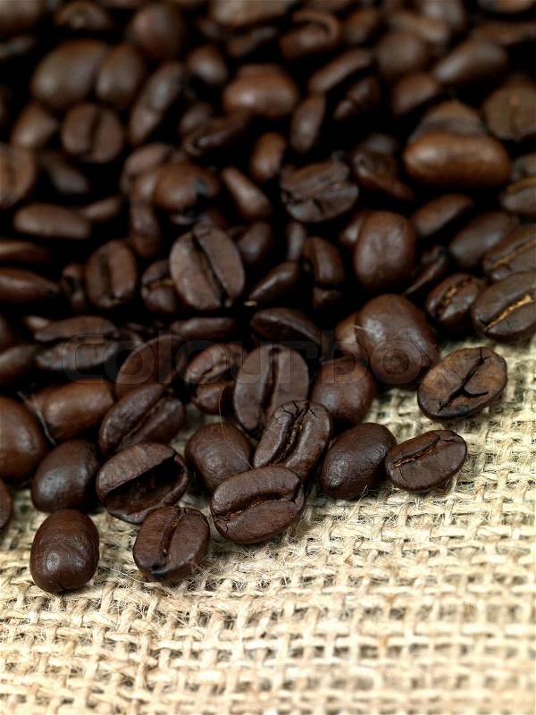 Fresh coffee beans on brown hessian bags, stock photo