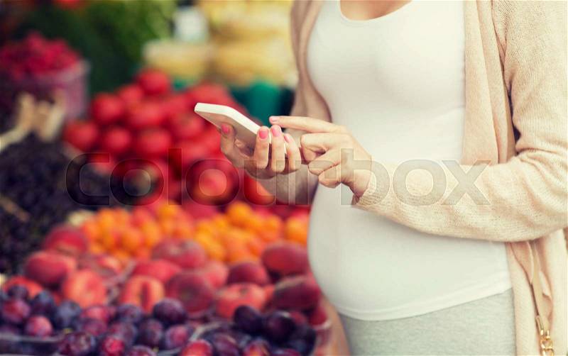 Sale, shopping, food, pregnancy and people concept - close up of pregnant woman with smartphone at street market, stock photo