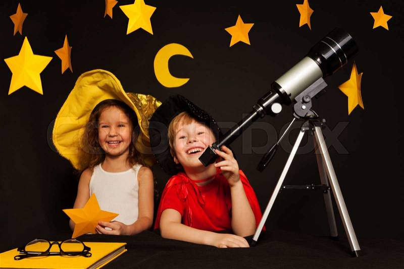 Happy five years old kids, boy and girl playing sky watchers stargazing with telescope, stock photo