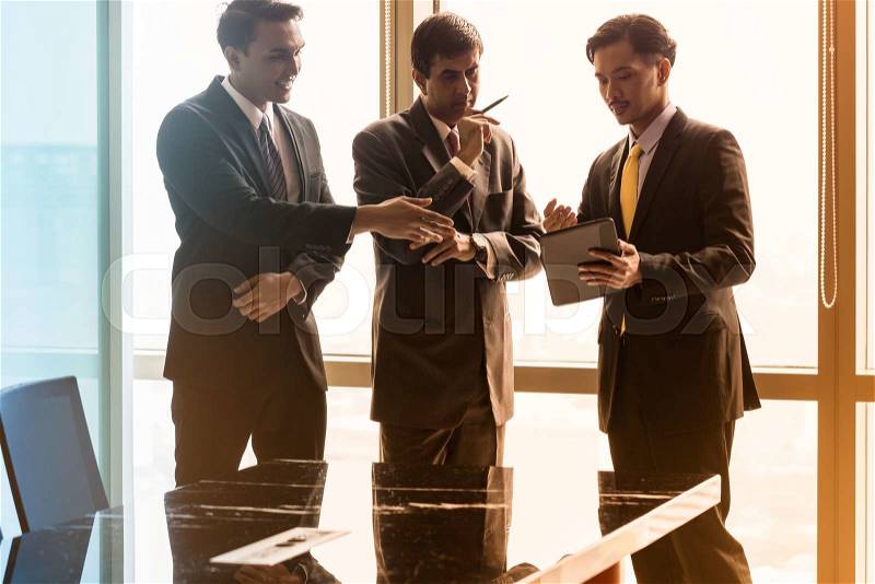 Asian business people having conversation in front of window in conference room, filtered image, stock photo