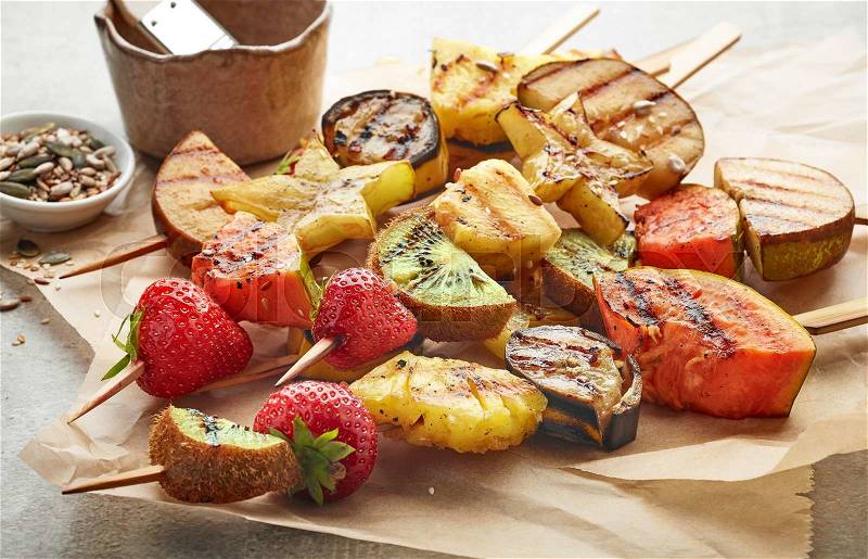 Various grilled fruit pieces on wooden skewers, stock photo