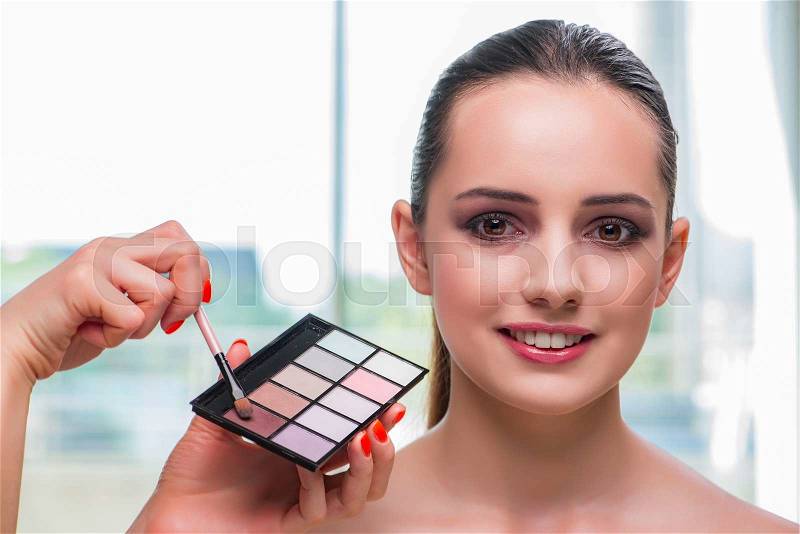 Beautiful woman during make-up cosmetics session, stock photo