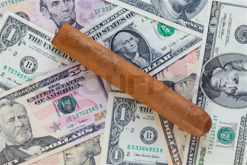 Detail of luxury Cuban cigar on the US dollar banknotes, stock photo