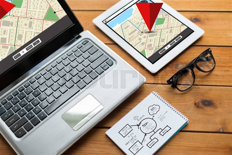 Navigation, responsive design and technology concept - close up of on laptop computer, tablet pc, notebook and eyeglasses with gps navigator map and scheme on wooden table, stock photo