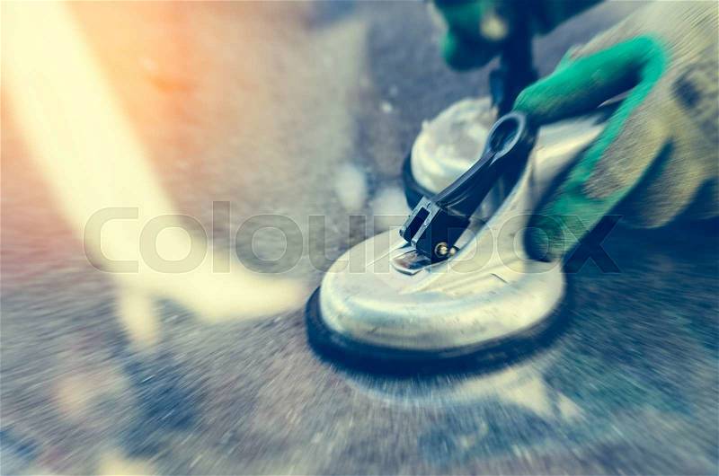 Motionblur worker wearing grove and holding Suction Cup Lifter on mirror, stock photo