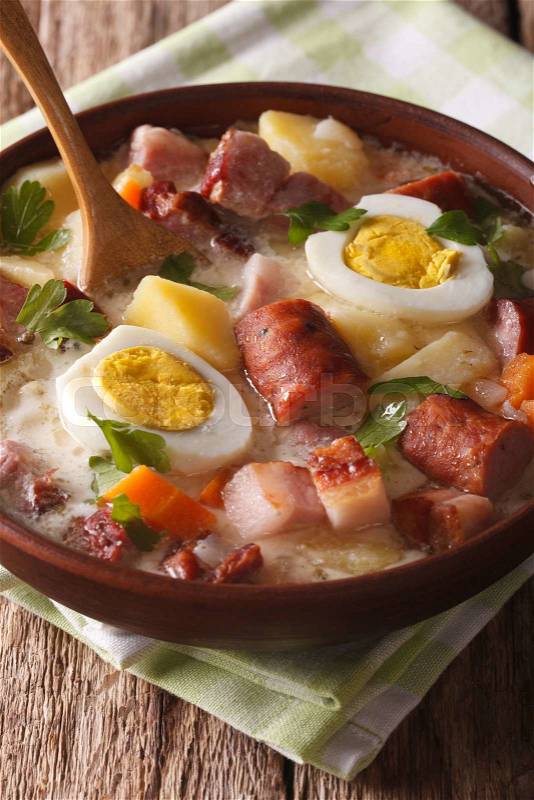 Delicious Polish soup Zurek with sausage and eggs in a bowl close-up. vertical\, stock photo