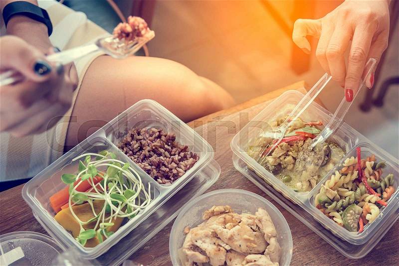 Women eating Healthy food in lunch box on wooden table. Healthy food concept, stock photo