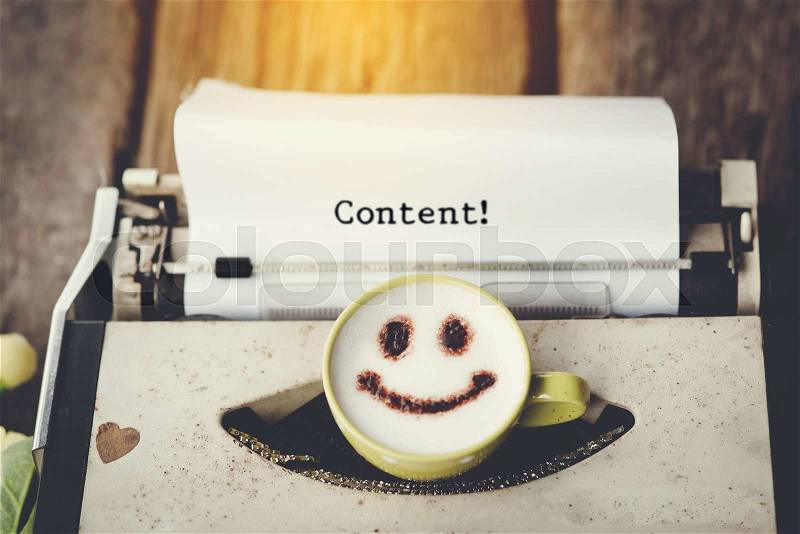 Typewriter with happy face coffee cup, sepia tone. with message content, stock photo