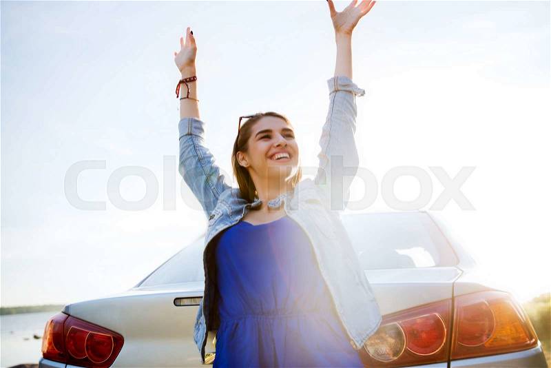 Summer vacation, holidays, travel, road trip and people concept - happy smiling teenage girl or young woman near car at seaside, stock photo