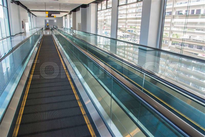 Long walkway of escalator at international airport terminal, stock photo