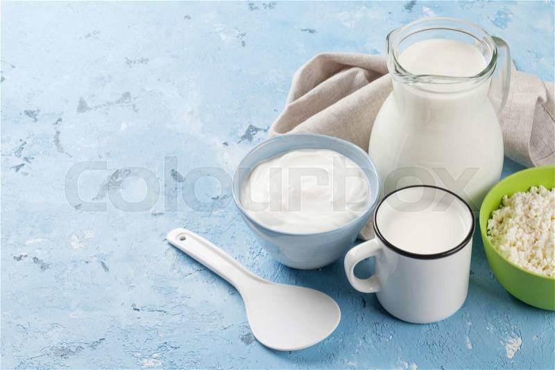 Dairy products on stone table. Sour cream, milk and curd cheese. View with copy space, stock photo
