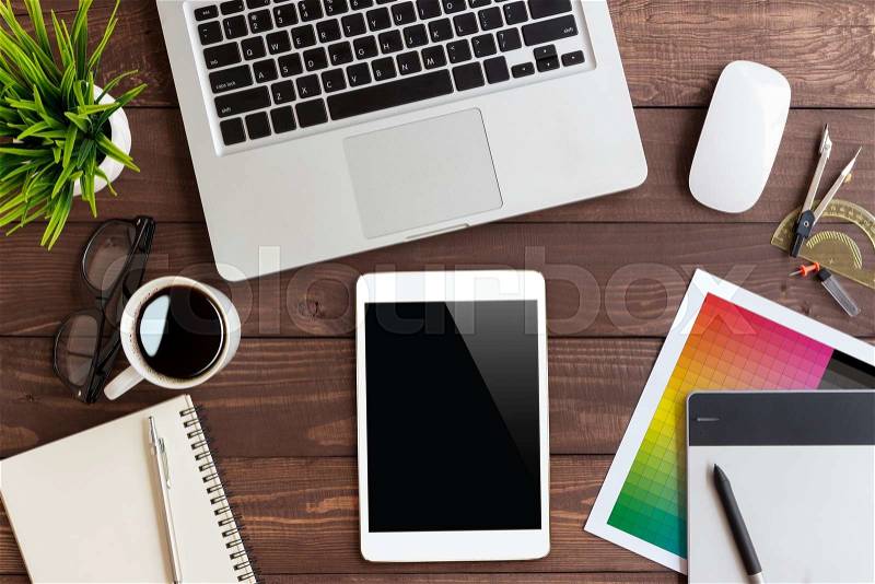 Tablet on creative workspace on top view, stock photo