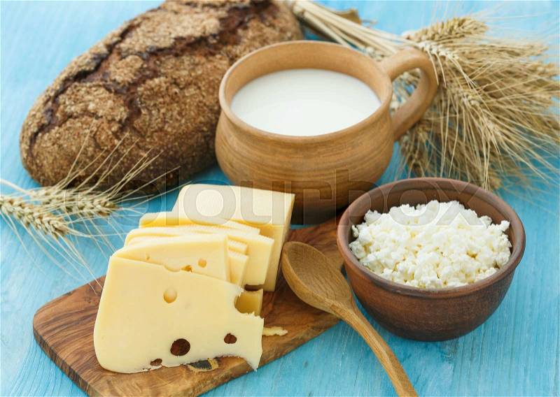 Cottage cheese, milk, bread and cheese on a wooden background - healthy breakfast concept, stock photo