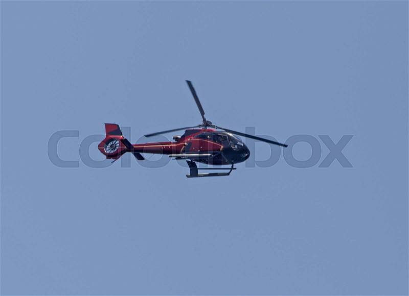 Red helicopter in a blue sky, stock photo