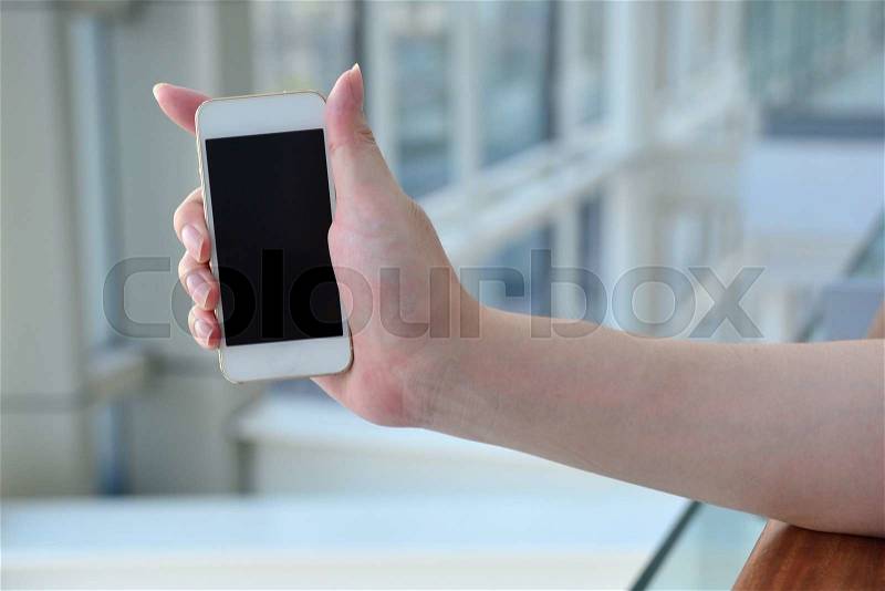 Man with modern mobile phone in hands touching on a blank screen. , stock photo