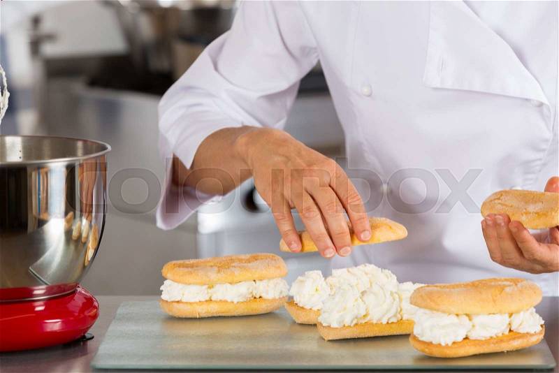 Chef pastry cream filling some biscuits, stock photo