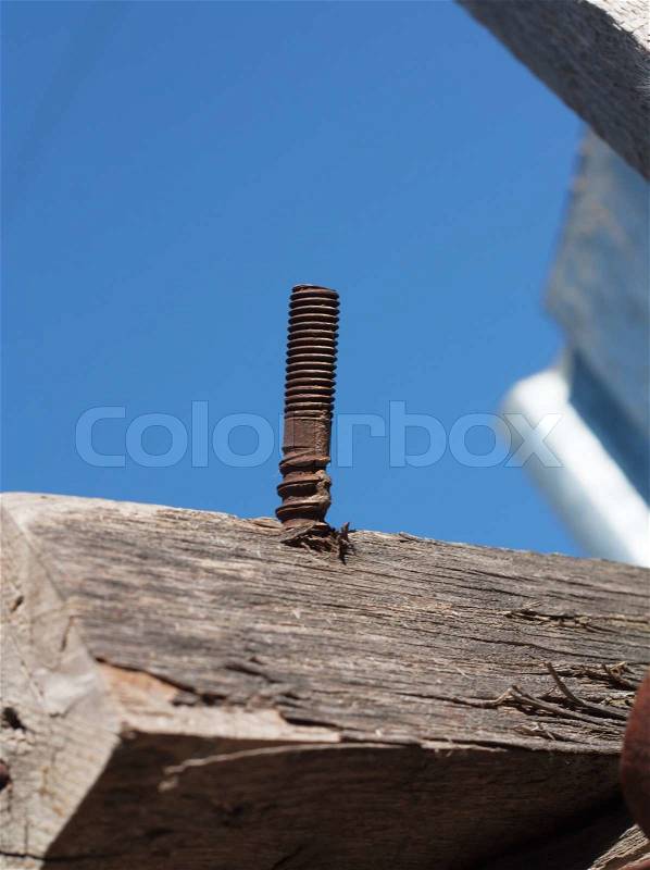 Rusty nail in obsolete wood plank, stock photo
