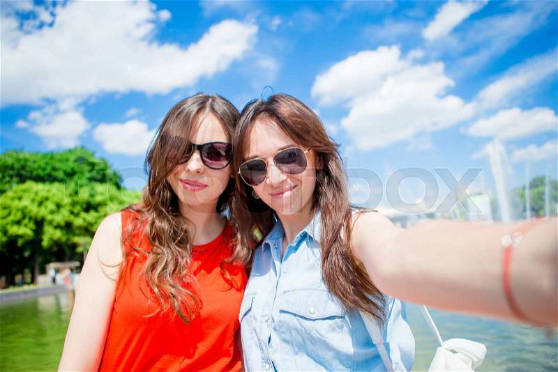 Caucasian girls making selfie background big fountain. Young tourist friends traveling on holidays outdoors smiling happy, stock photo
