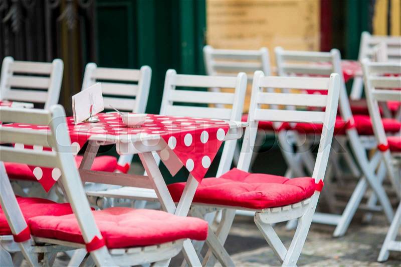 White wooden tables with chairs at summer open air cafe terrace. View of empty outdoor cafe in Europe, stock photo