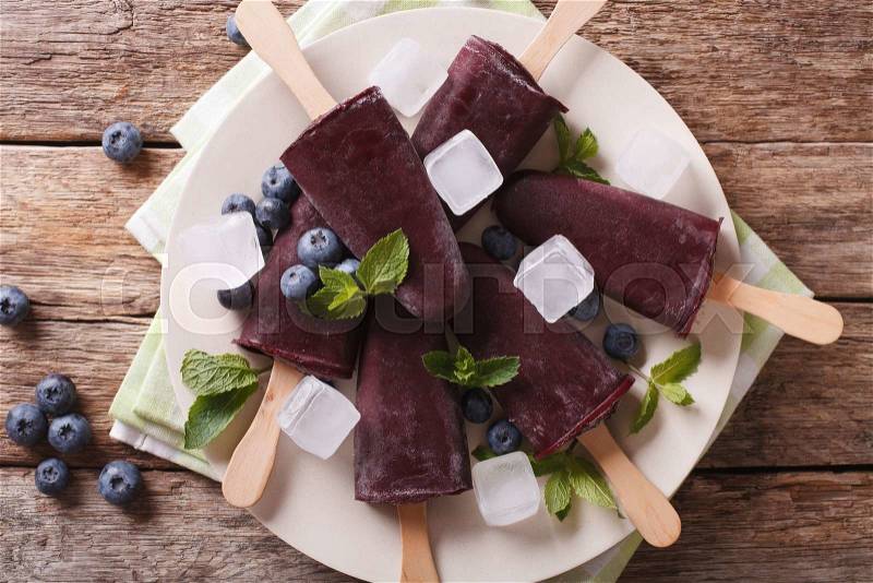 Delicious blueberry sorbet on a stick close-up on a plate on the table. horizontal view from above , stock photo