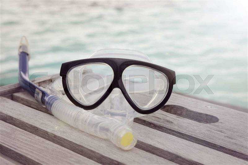 Diving mask and a snorkel on the wooden table, stock photo