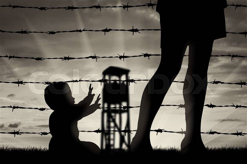 Refugee family concept. Silhouette of the child and refugee mothers legs near the fence of barbed wire, stock photo
