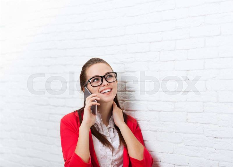 Businesswoman happy smile cell phone call problem wear red jacket glasses talking on mobile look up to copy space business woman over office wall, stock photo