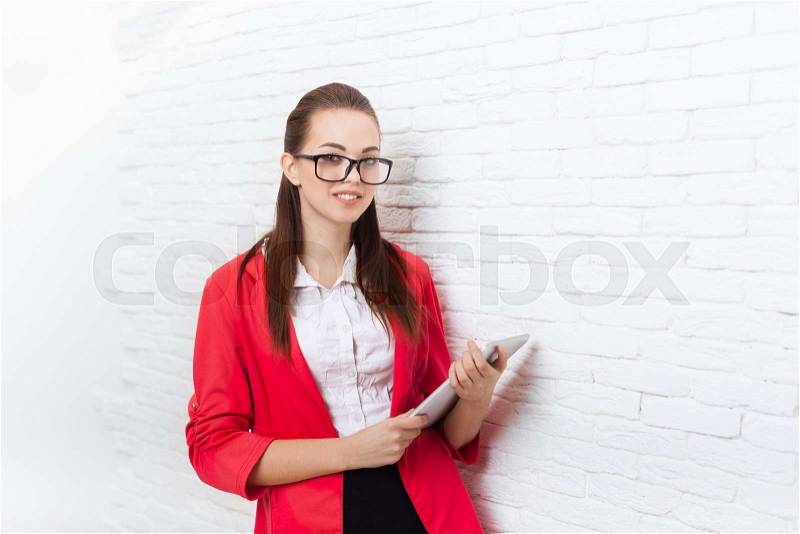 Businesswoman use tablet computer wear red jacket glasses happy smile business woman over office wall, stock photo