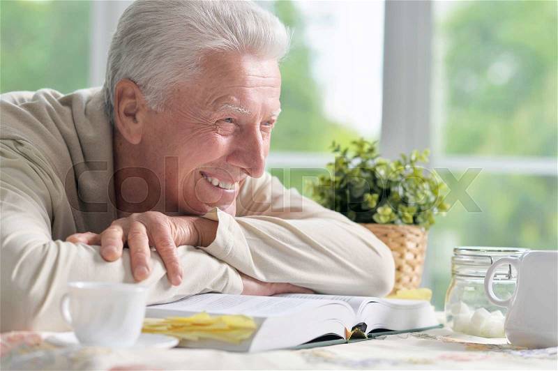 Portrait of a elderly happy man with book, stock photo