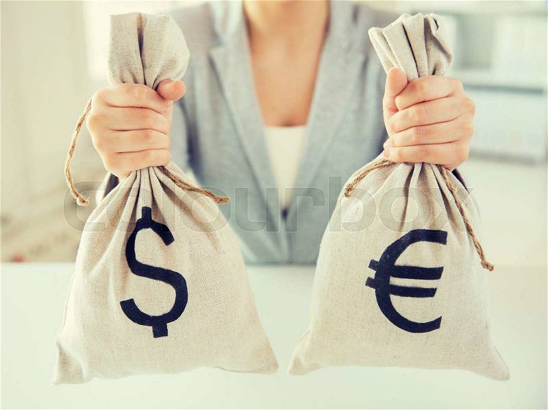 Business, finance, saving, banking and people concept - close up of woman hands holding dollar and euro money bags, stock photo