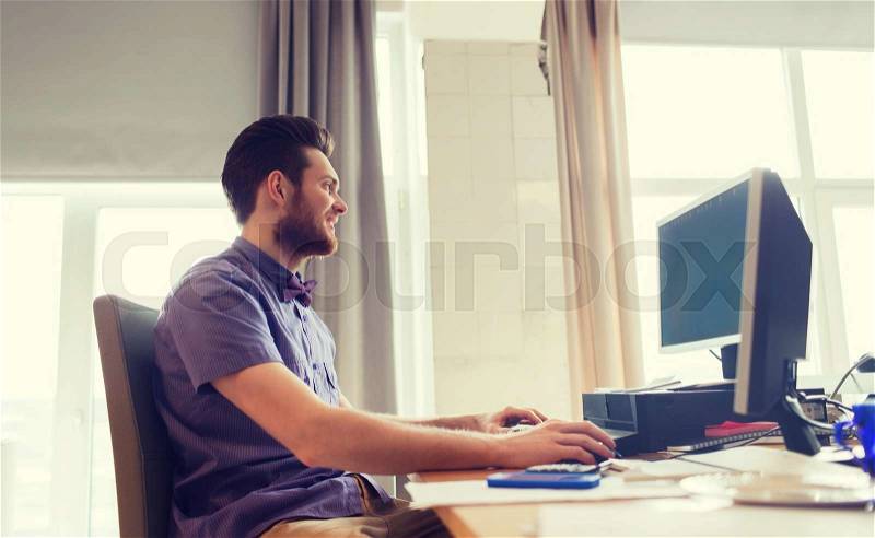 Business, startup and people concept - happy businessman or creative male office worker with computer, stock photo
